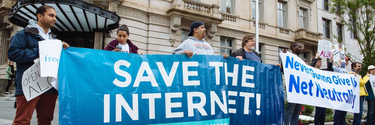 net neutrality supporters hold banners