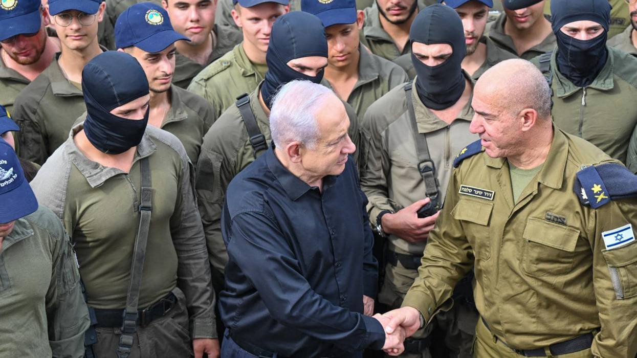 Netanyahu shakes hands with an Israeli naval commander while surrounded by troops in black balaclavas.