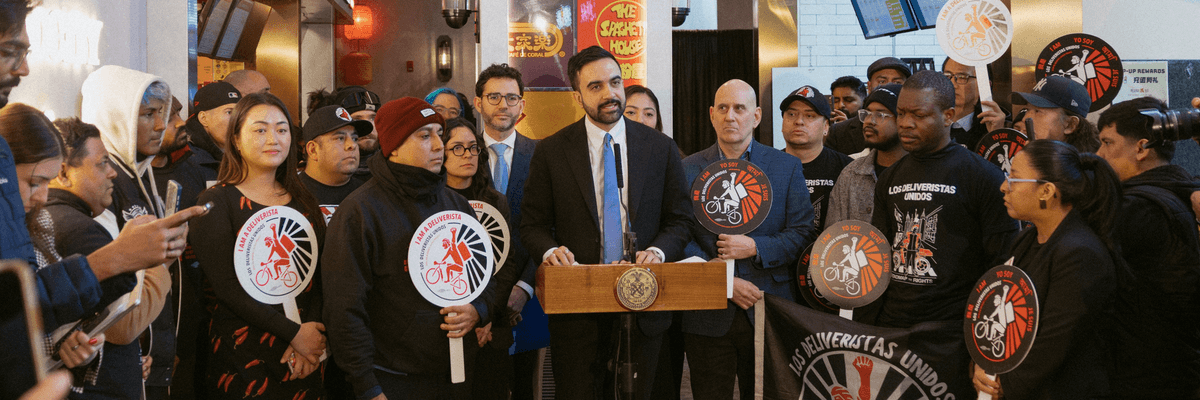New York City Mayor Zohran Mamdani stands with delivery workers