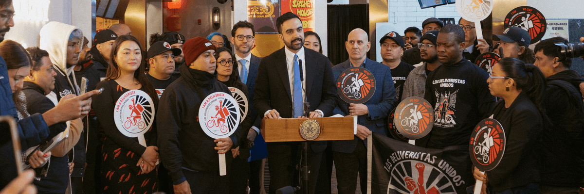 New York City Mayor Zohran Mamdani stands with delivery workers