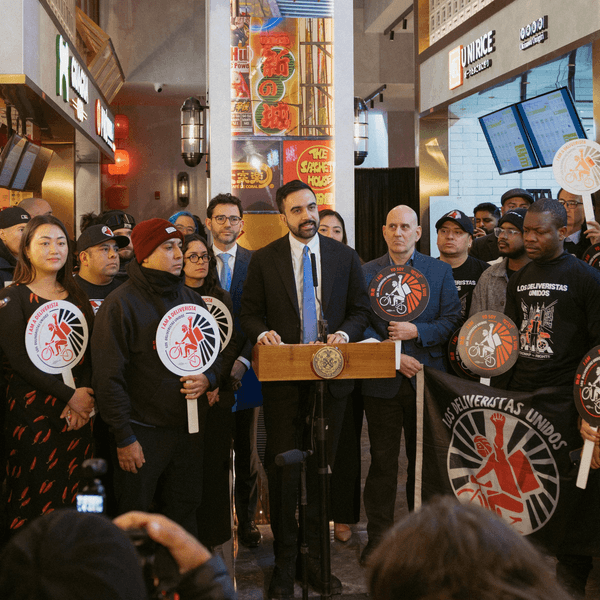 New York City Mayor Zohran Mamdani stands with delivery workers