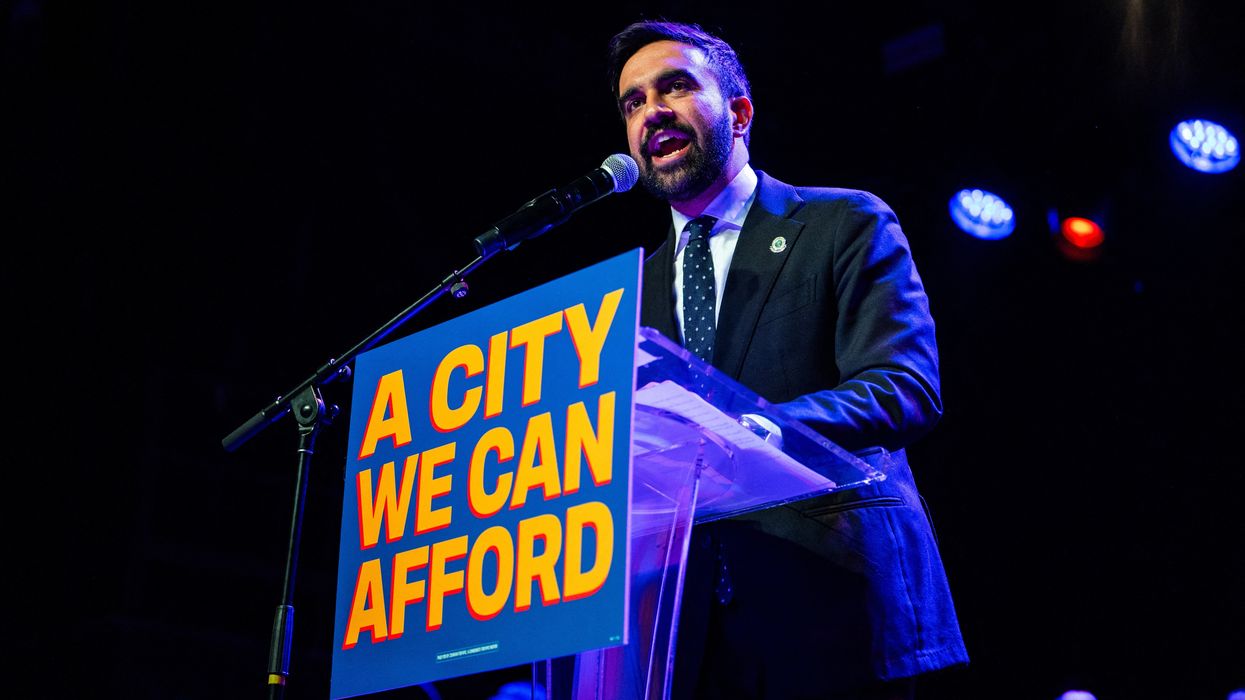 New York City mayoral candidate Zohran Mamdani speaks enthusiastically into a mic.