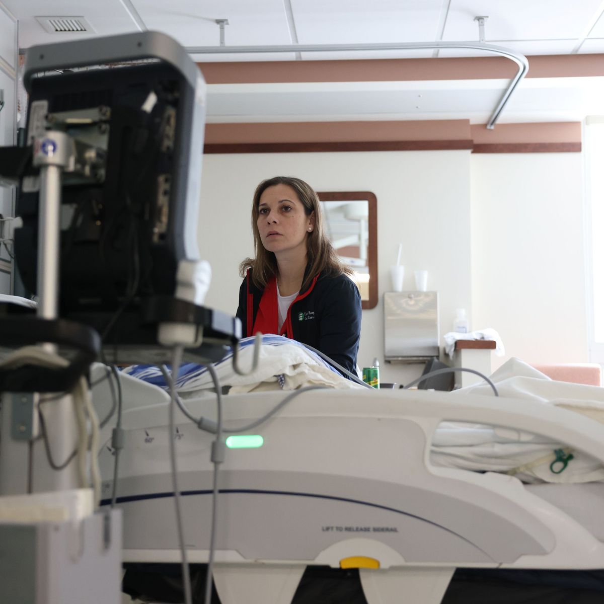 Nurse looks for a vein so that she can give a patient a peripherally inserted central