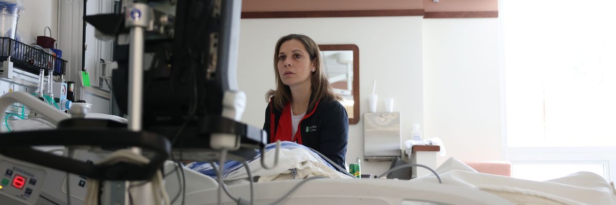 Nurse looks for a vein so that she can give a patient a peripherally inserted central