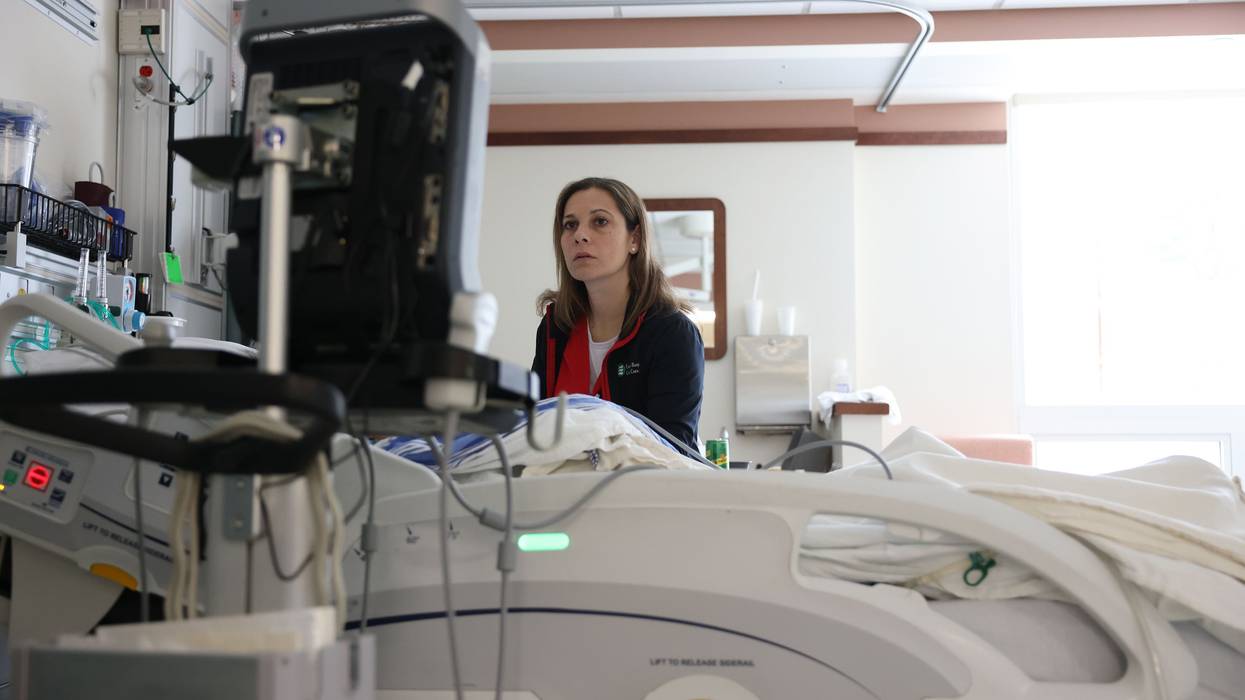 Nurse looks for a vein so that she can give a patient a peripherally inserted central