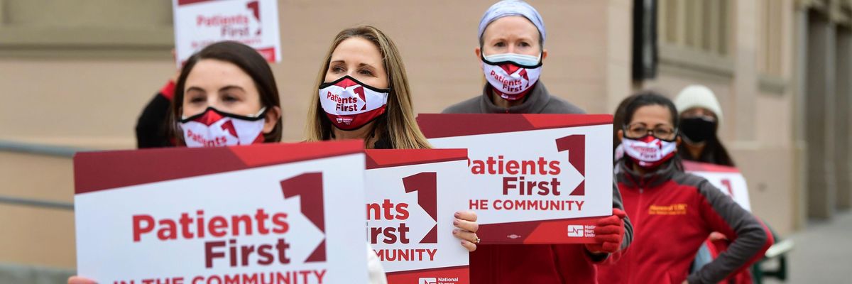 Nurses march carrying signs reading, "Patients first."