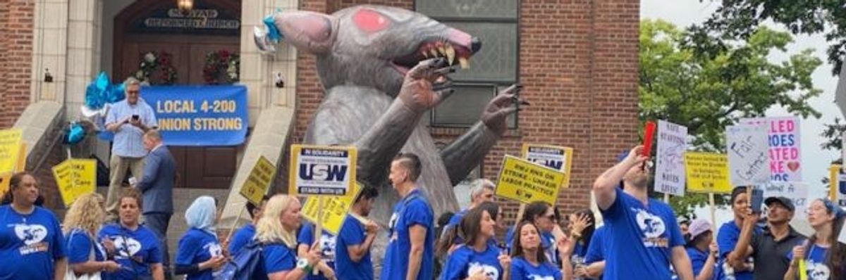 Nurses on a picket line with Scabby in the background. 