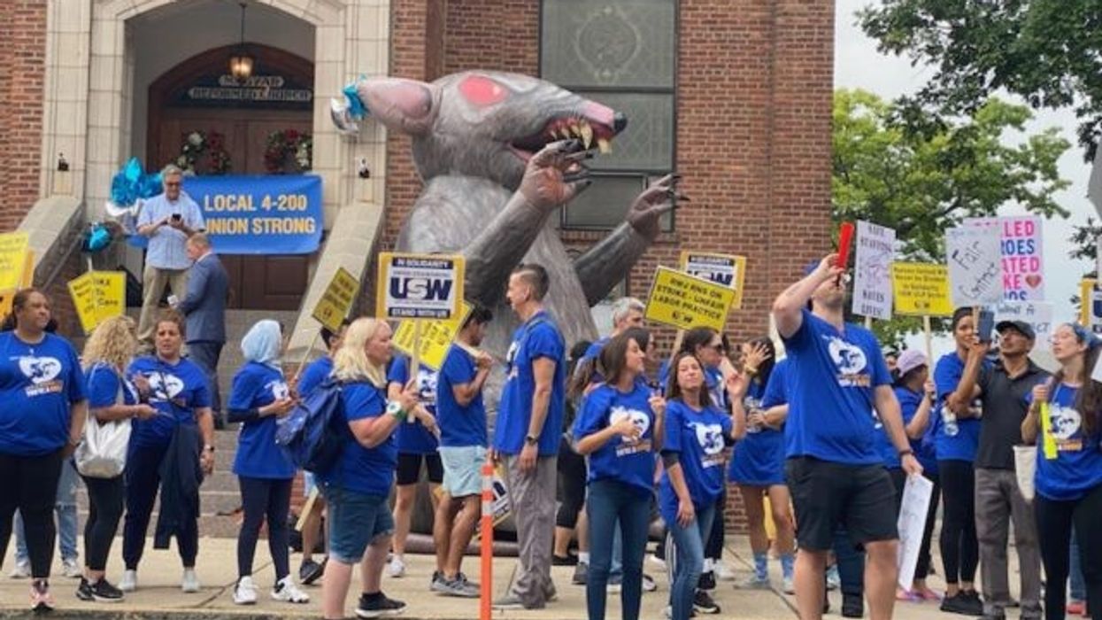 Nurses on a picket line with Scabby in the background.