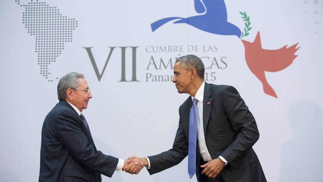 Obama and Raul Castro shake hands.