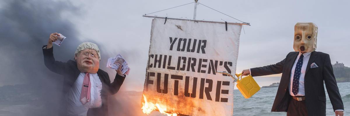 Ocean Rebellion staged a theatrical action with a Boris Johnson head and an "Oil head" burning a boat on Marazion beach on June 5, 2021 in Cornwall, United Kingdom. (Photo: Gav Goulder/In Pictures via Getty Images)