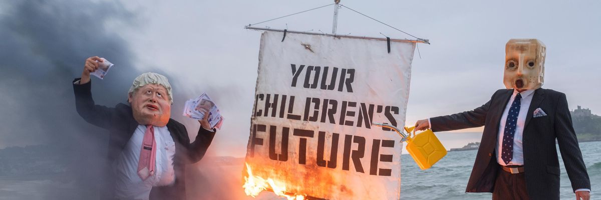 Ocean Rebellion staged a theatrical action with a Boris Johnson head and an "Oil head" burning a boat on Marazion beach on June 5, 2021 in Cornwall, United Kingdom.(Photo: Gav Goulder/In Pictures via Getty Images)
