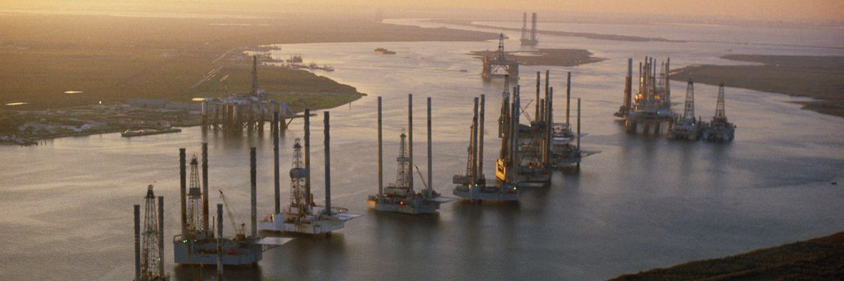 Offshore oil drilling platforms in the sunset.