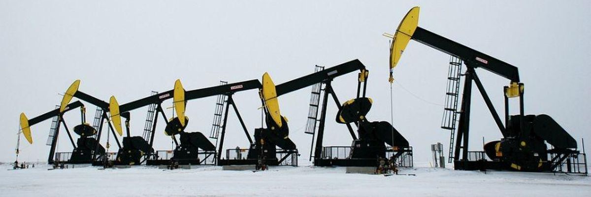 Oil pumps lined up in the snow.