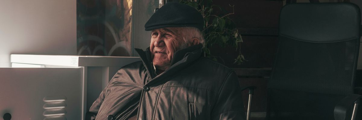 Old man leaning in chair.