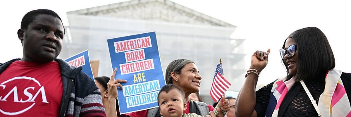 Olga Urbina holds her nine-month-old son, Ares Webster, as people gather outside the U.S. Supreme Court