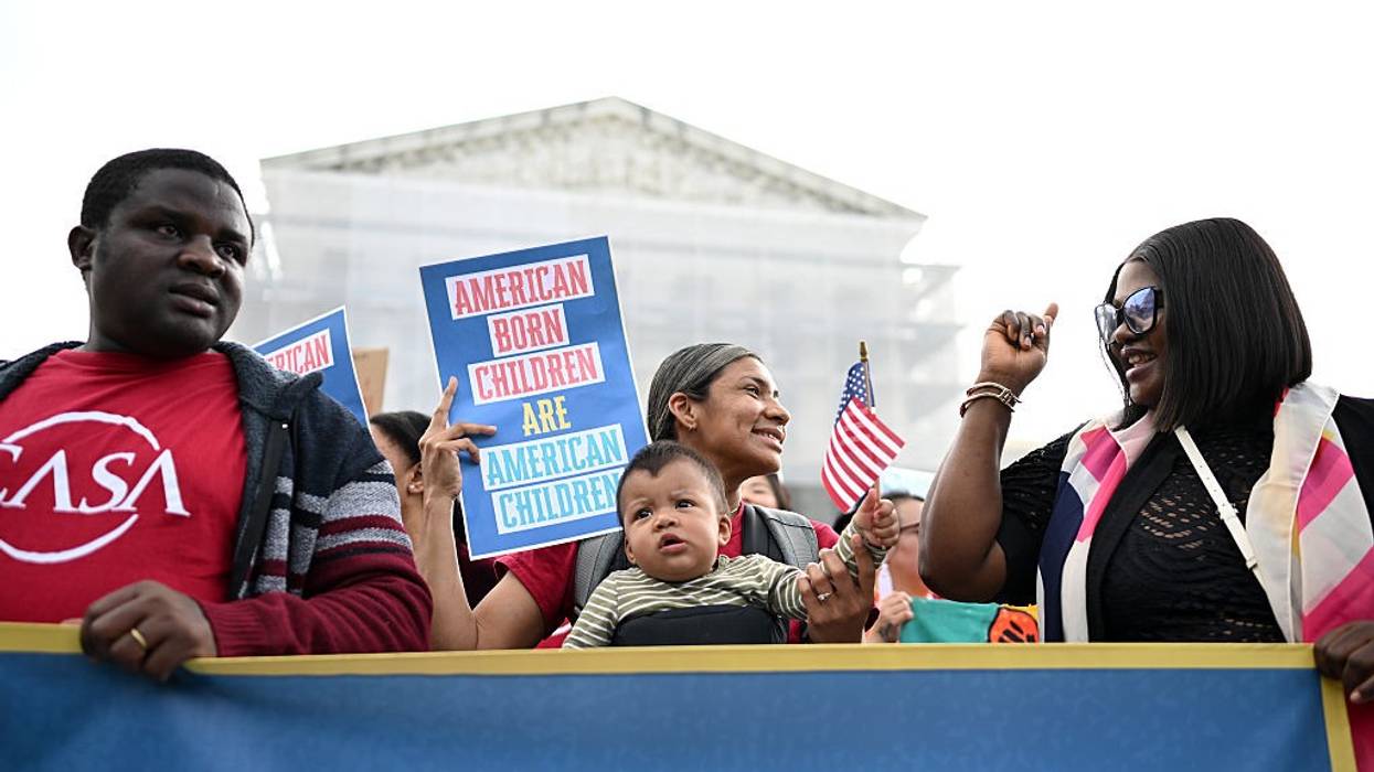 Olga Urbina holds her nine-month-old son, Ares Webster, as people gather outside the U.S. Supreme Court