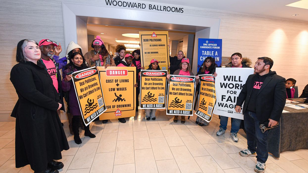 One Fair Wage supporters attend a rally and hold signs advocating for higher wages