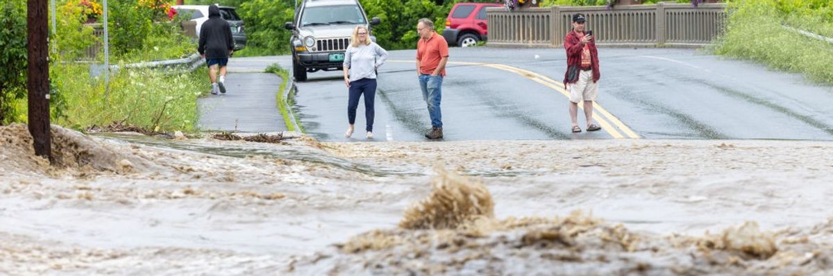 Onlookers check out a flooded road