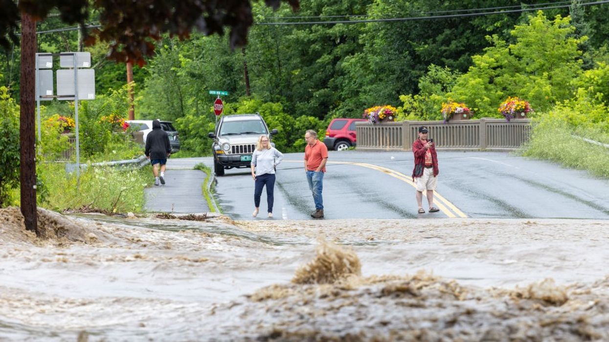 Onlookers check out a flooded road