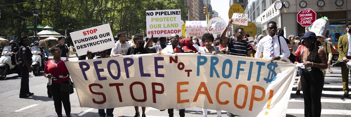 Opponents of EACOP carry a banner in NYC