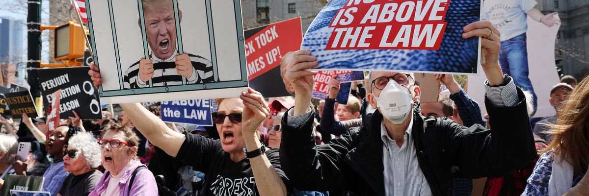 Opponents of former President Donald Trump gather outside of the Manhattan Criminal Court during his arraignment on April 4, 2023 in New York City.