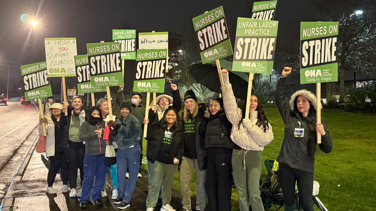 Oregon nurses on a picket line hold up signs announcing they're on strike