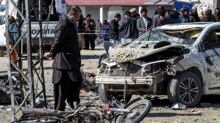 Pakistani security officials inspect the site of a political bombing