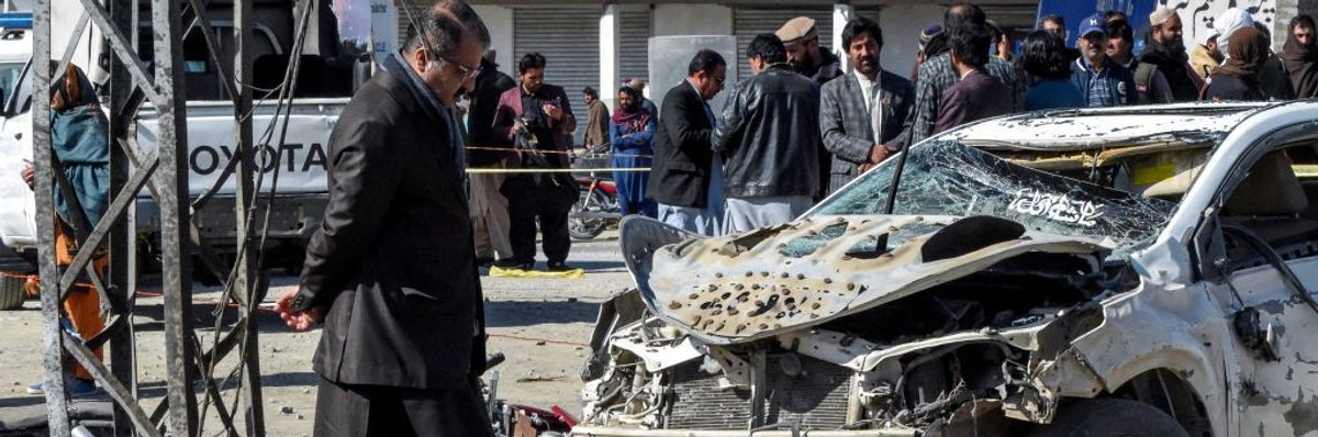 Pakistani security officials inspect the site of a political bombing