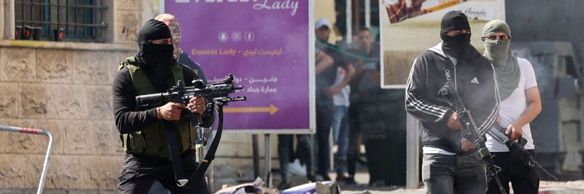 Palestinian armed militants take up position during a confrontation