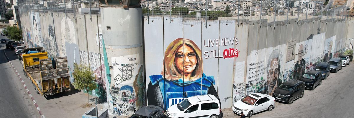 Palestinian artist Takiyuddin Sebatin preparing a graffiti on the separation wall in the West Bank for US President Joe Biden, who is planning to visit Bethlehem in the middle of this month, depicting the photograph of Al Jazeera journalist Shireen Abu Akleh, killed by Israeli forces, on July 06, 2022 in Bethlehem, West Bank. 