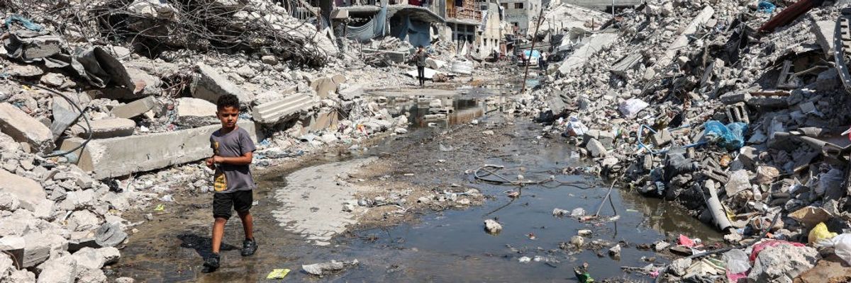 Palestinian boy walks through a puddle of sewage water in the Jabalia refugee camp in Gaza