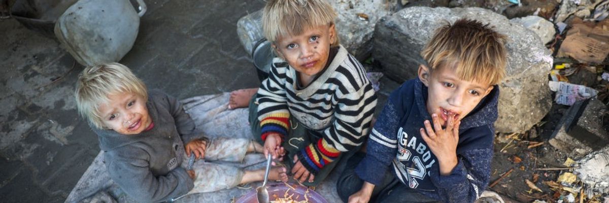 Palestinian boys share plate of food in Gaz