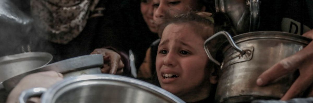 Palestinian child cries waiting for food in Rafah