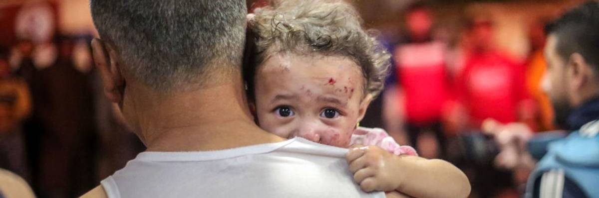 Palestinian child in her father's arms in Khan Yunis, Gaza