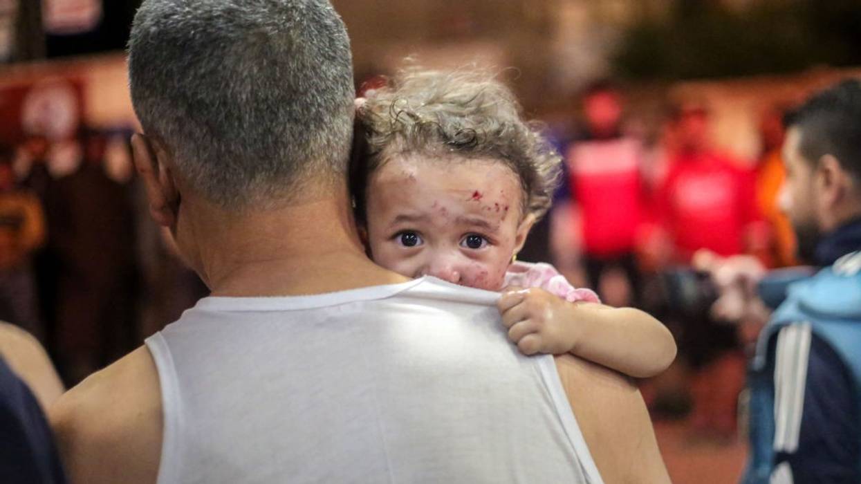 Palestinian child in her father's arms in Khan Yunis, Gaza