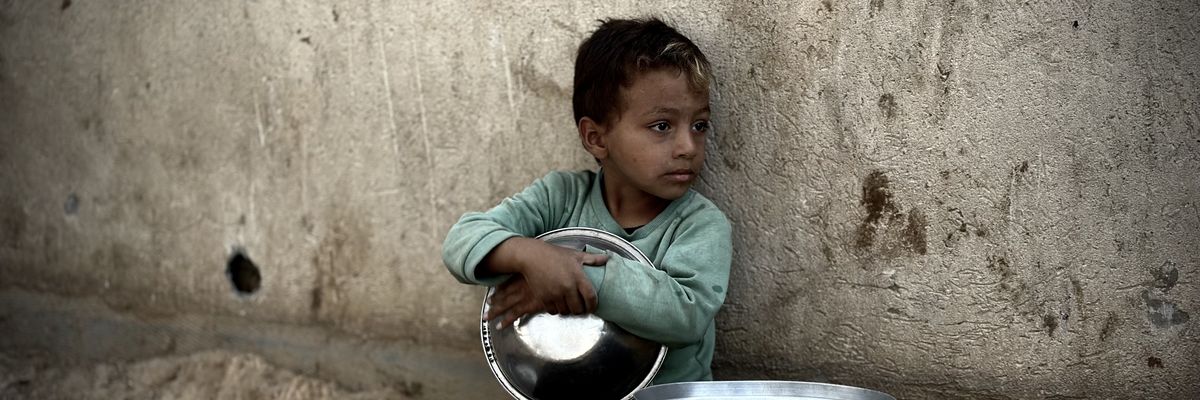 Palestinian child is seen with a pot