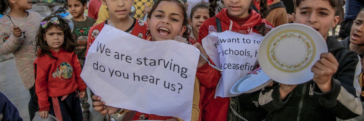 Palestinian children holding banners and empty bowl