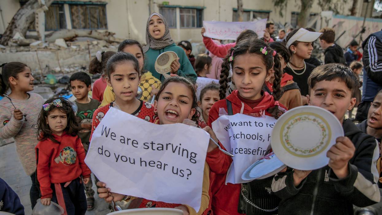 Palestinian children holding banners and empty bowl
