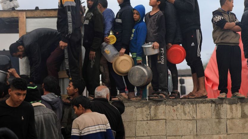 Palestinian children in need line up to receive food