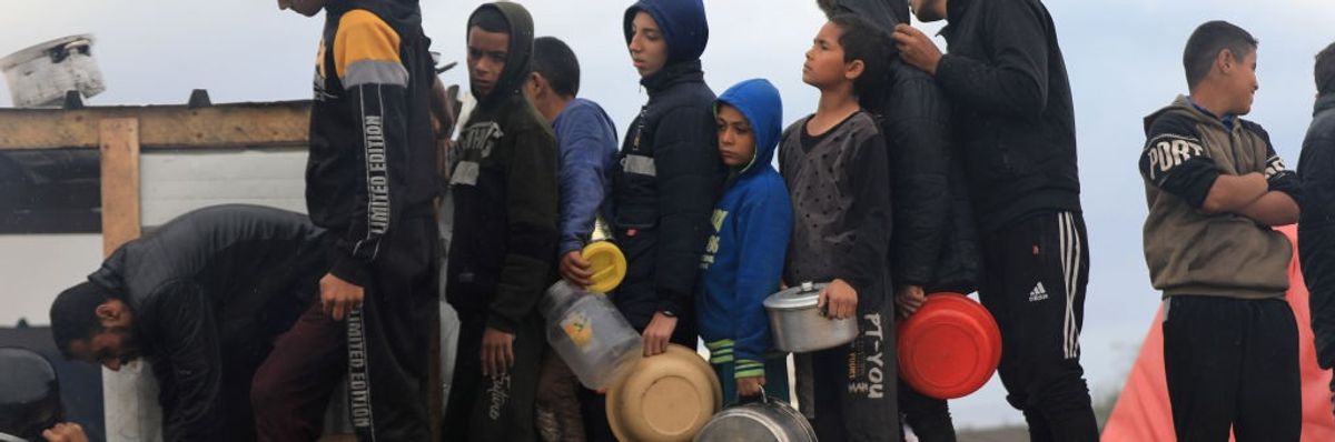 Palestinian children in need line up to receive food