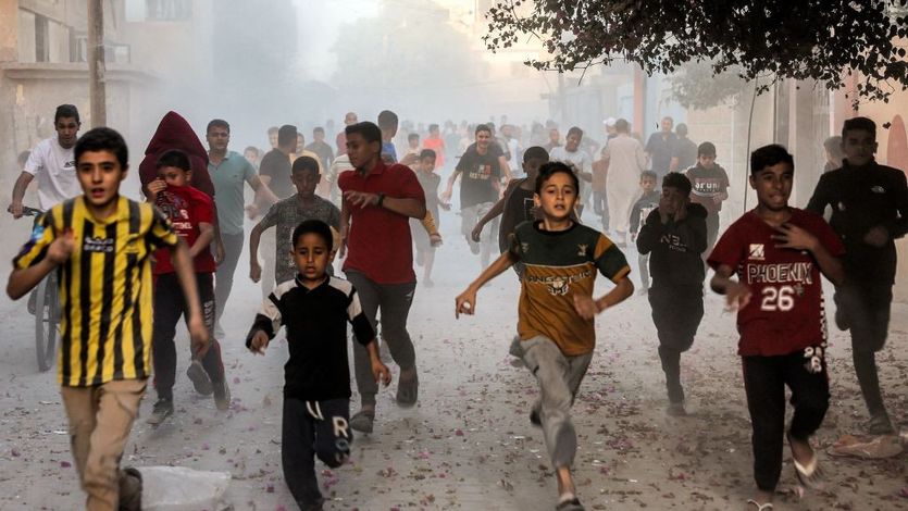 Palestinian children run to flee Israel bombs in Gaza