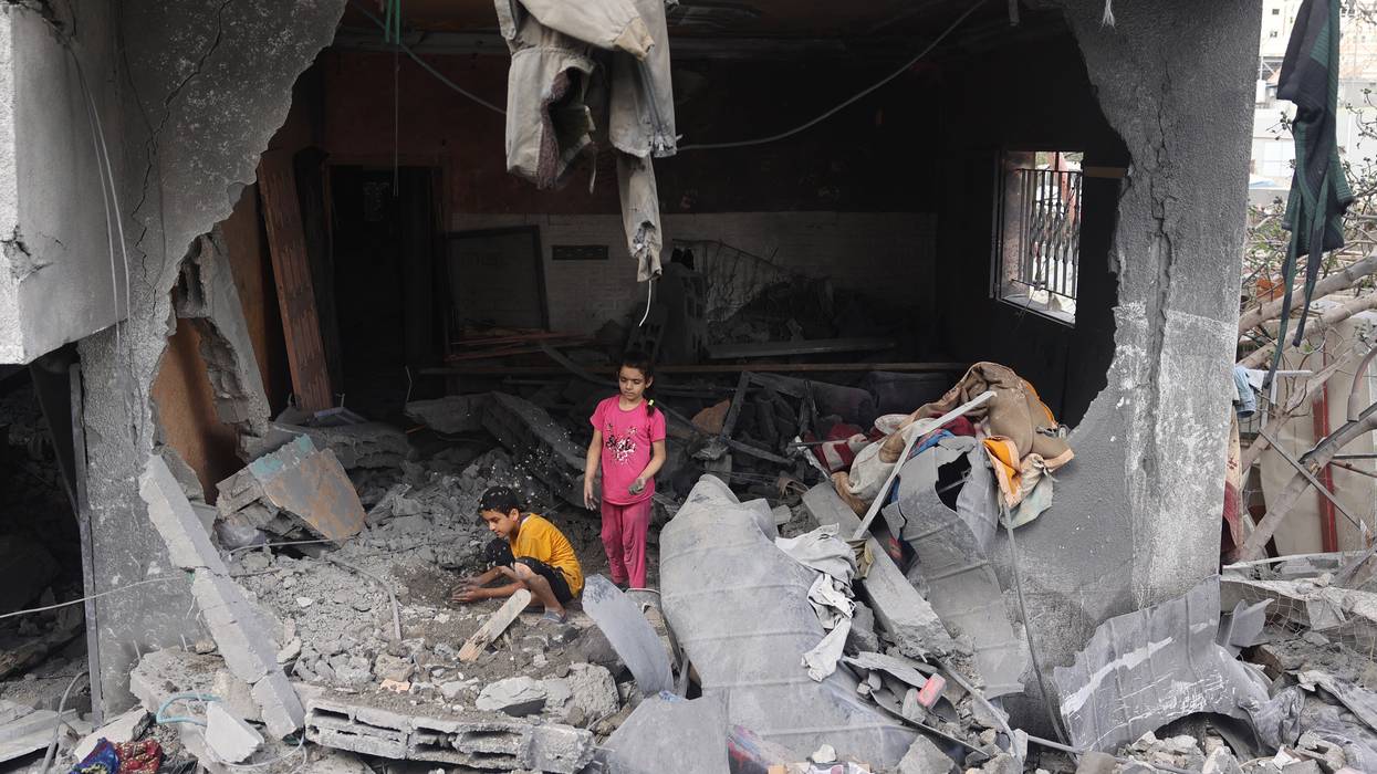 Palestinian children search rubble in Gaza.