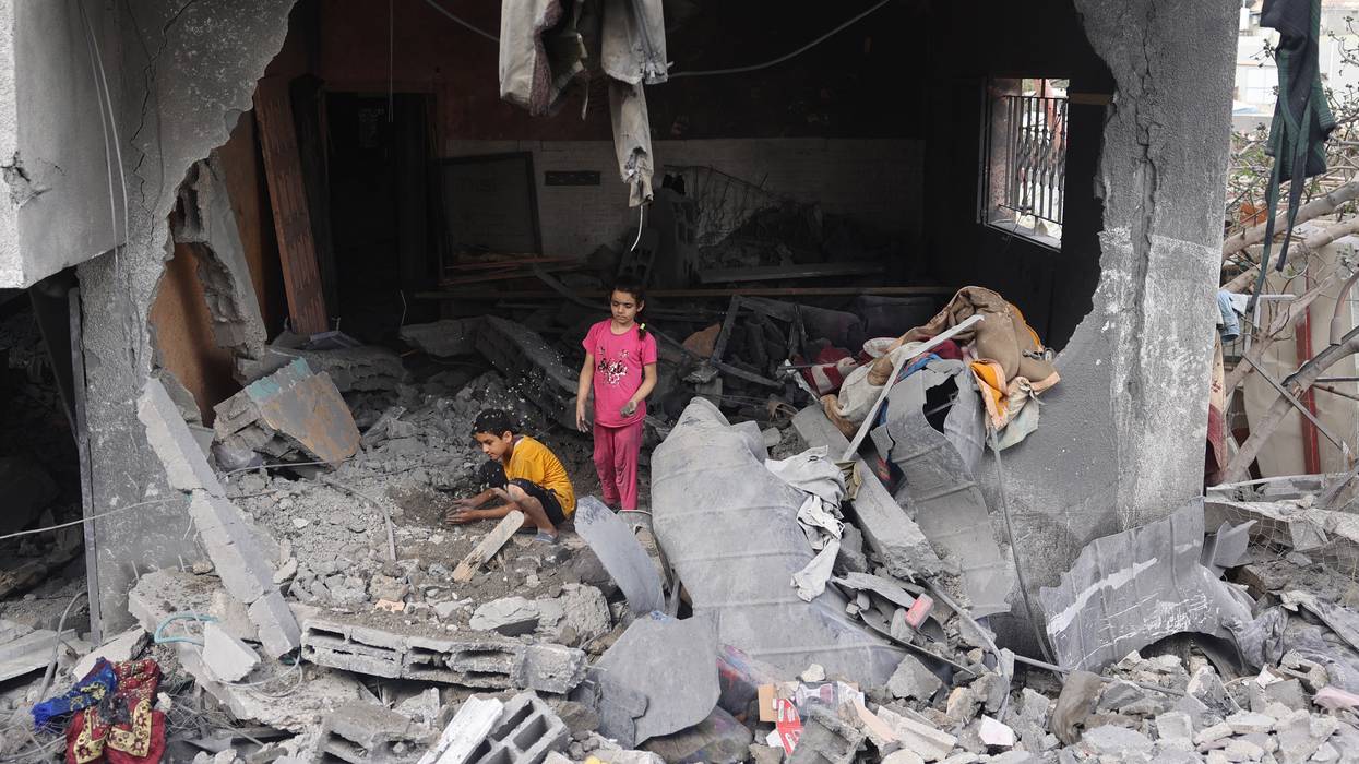 Palestinian children search rubble in Gaza.