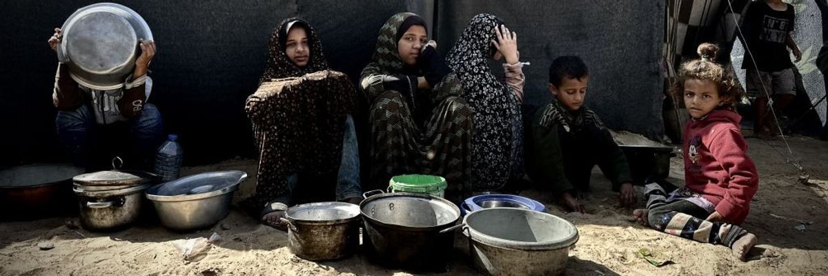 Palestinian children wait for food