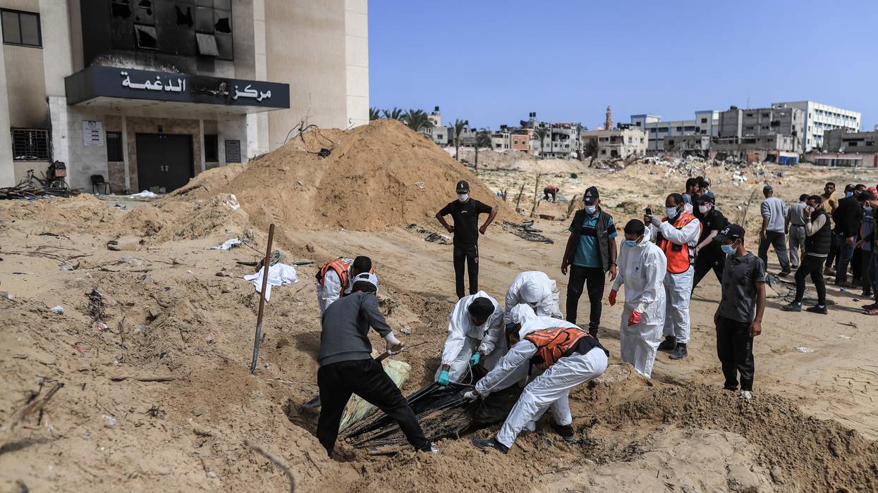 Palestinian civil defense workers remove bodies from rubble in Khan Younis.