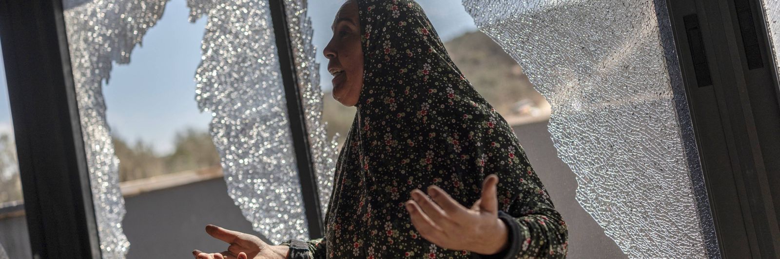 palestinian-hanan-hamayei-gestures-as-she-stands-near-the-shattered-glass-of-her-home-following-a-reported-attack-by-israeli-set.jpg?id=68488099&width=1200&height=400&coordinates=0%2C1055%2C0%2C614