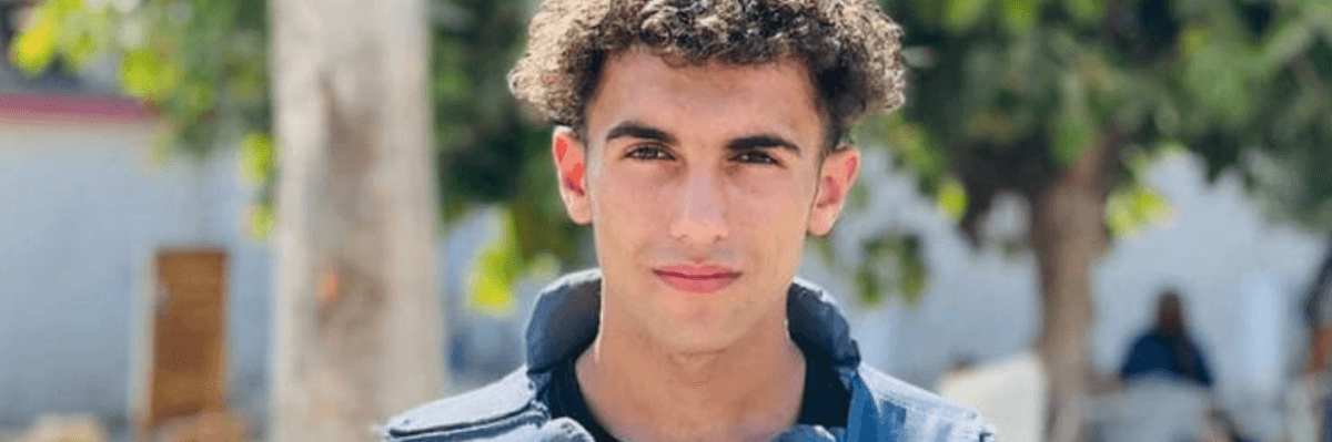 Palestinian journalist Hassan Hamad holds a photo of journalists killed by Israel in Gaza