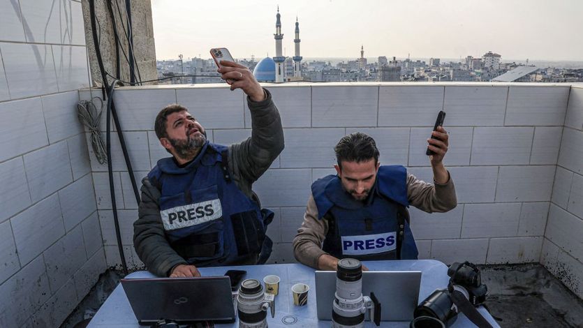 Palestinian journalists attempt to connect to the internet using their phones