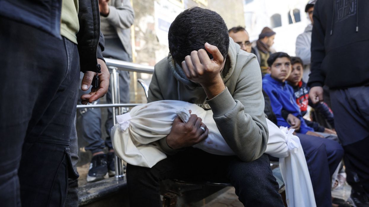 Palestinian man carries body of young brother.