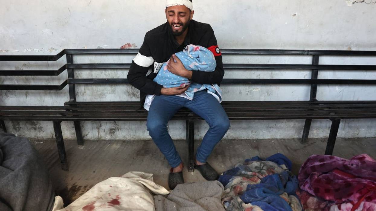 Palestinian man holds dead child killed by Israeli bombing
